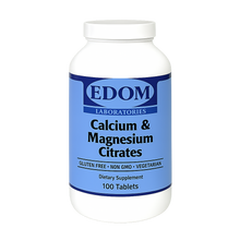 A white plastic bottle of EDOM LABORATORIES Calcium & Magnesium Citrates dietary supplement containing 100 tablets. The label is deep blue with white and black text showing “Calcium & Magnesium Citrates,” “GLUTEN FREE • NON GMO • VEGETARIAN,” and “Dietary Supplement